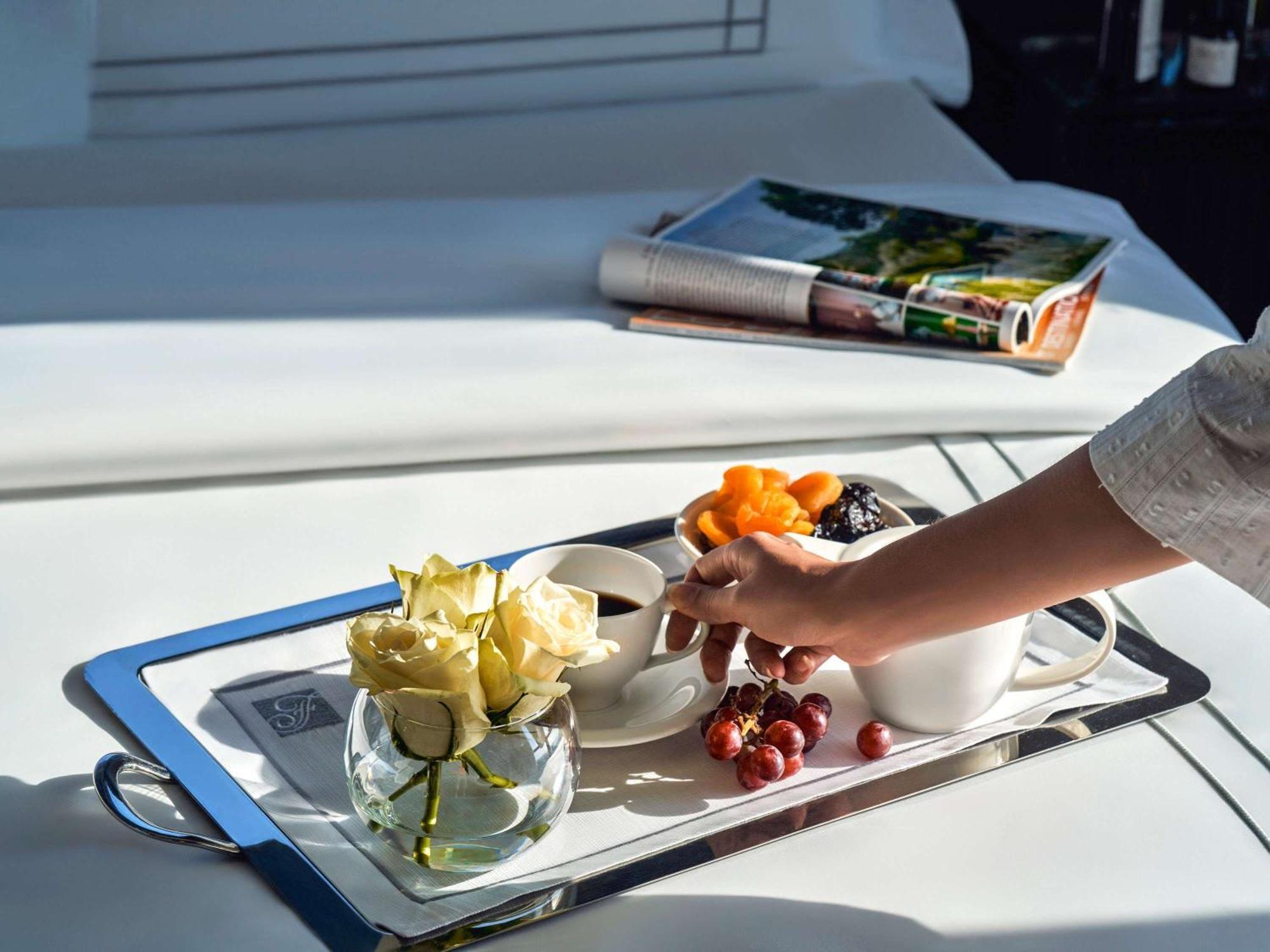 Fairmont Nile City Cairo Exterior photo A butler serving a tray of fruit and flowers
